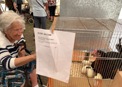 Lady resident looking at chickens in a cage