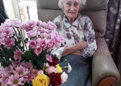 Lady resident sitting with her flower arrangement