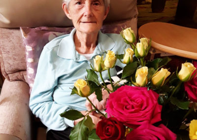 Lady resident sitting with her floral arrangement