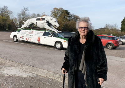 Resident from Lulworth House standing by a greyhound themed car at a dog racing stadium
