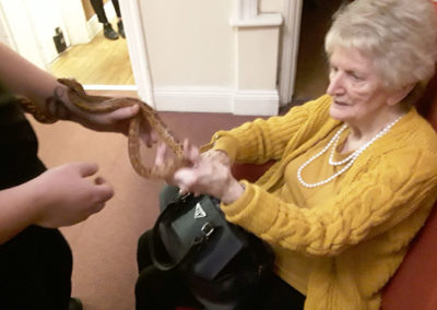 Zoolab staff member with a lady resident, looking at a snake