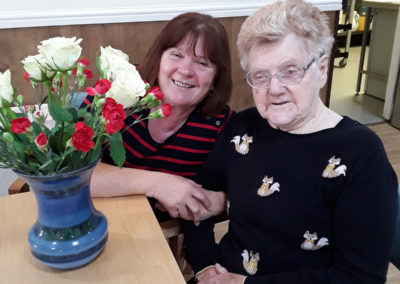 Resident and family member flower arranging together at Sonya Lodge