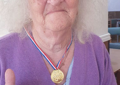 Resident showing off her medal at Sonya Lodge Residential Care Home