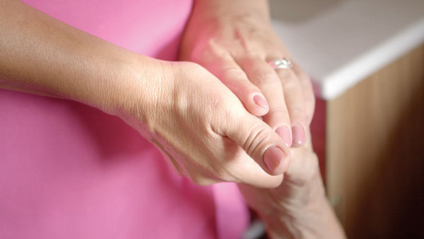 Carer holding elderly care home residents hand