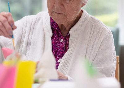 A resident at The Old Downs Residential Care Home enjoying an arts and crafts activity